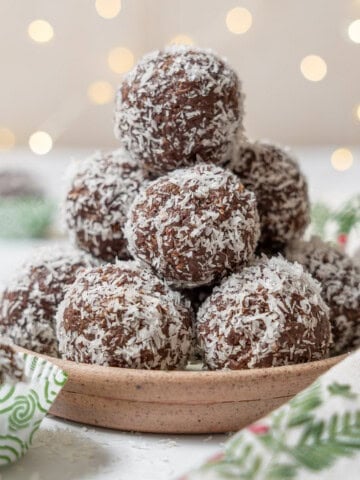 stack of chocolate coconut balls on a plate.