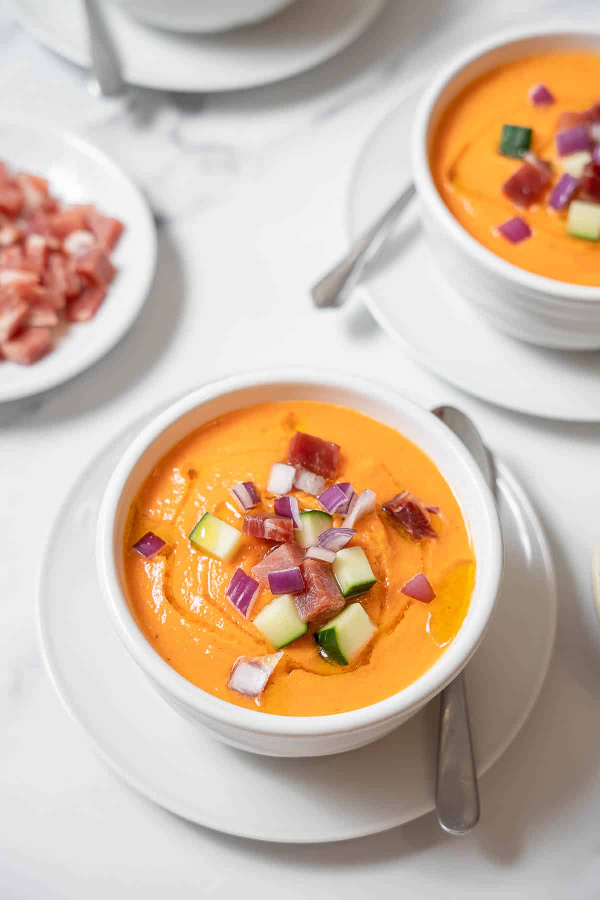 two bowls of gazpacho with spoons.