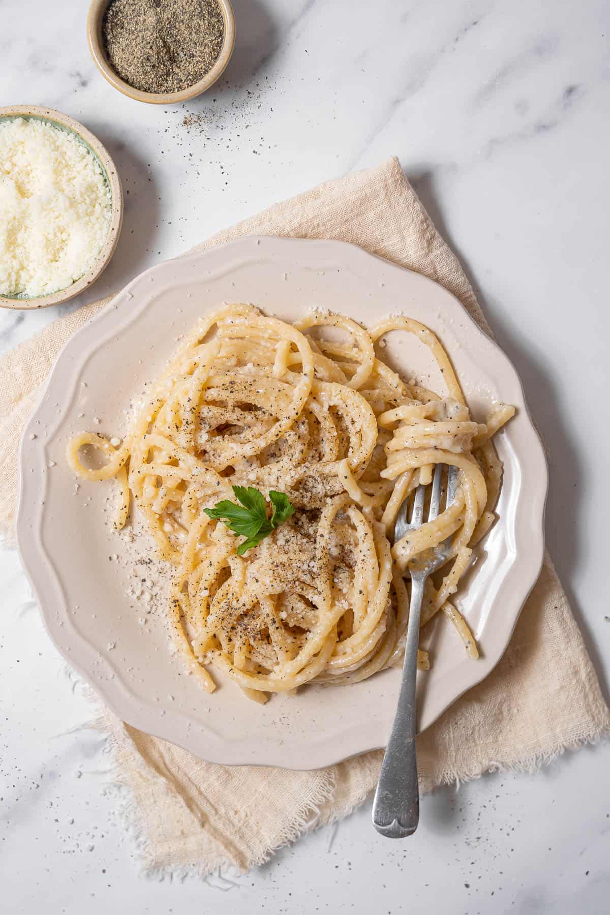 plate of cacio e pepe with Parmesan cheese.