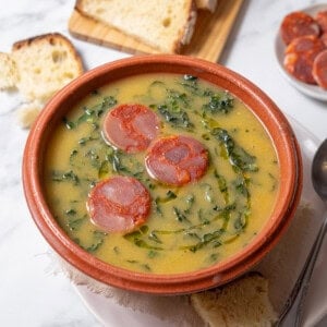 bowl of caldo verde with a spoon and bread.