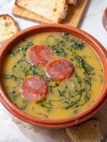 bowl of caldo verde with a spoon and bread.