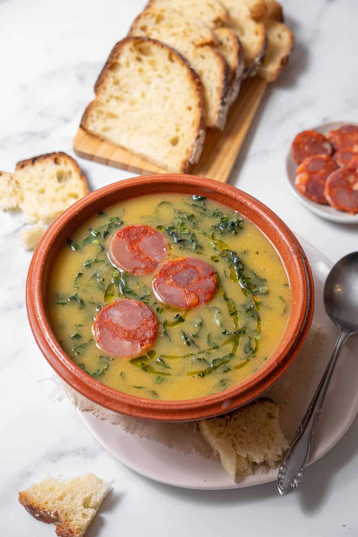 bowl of caldo verde with a spoon and bread.