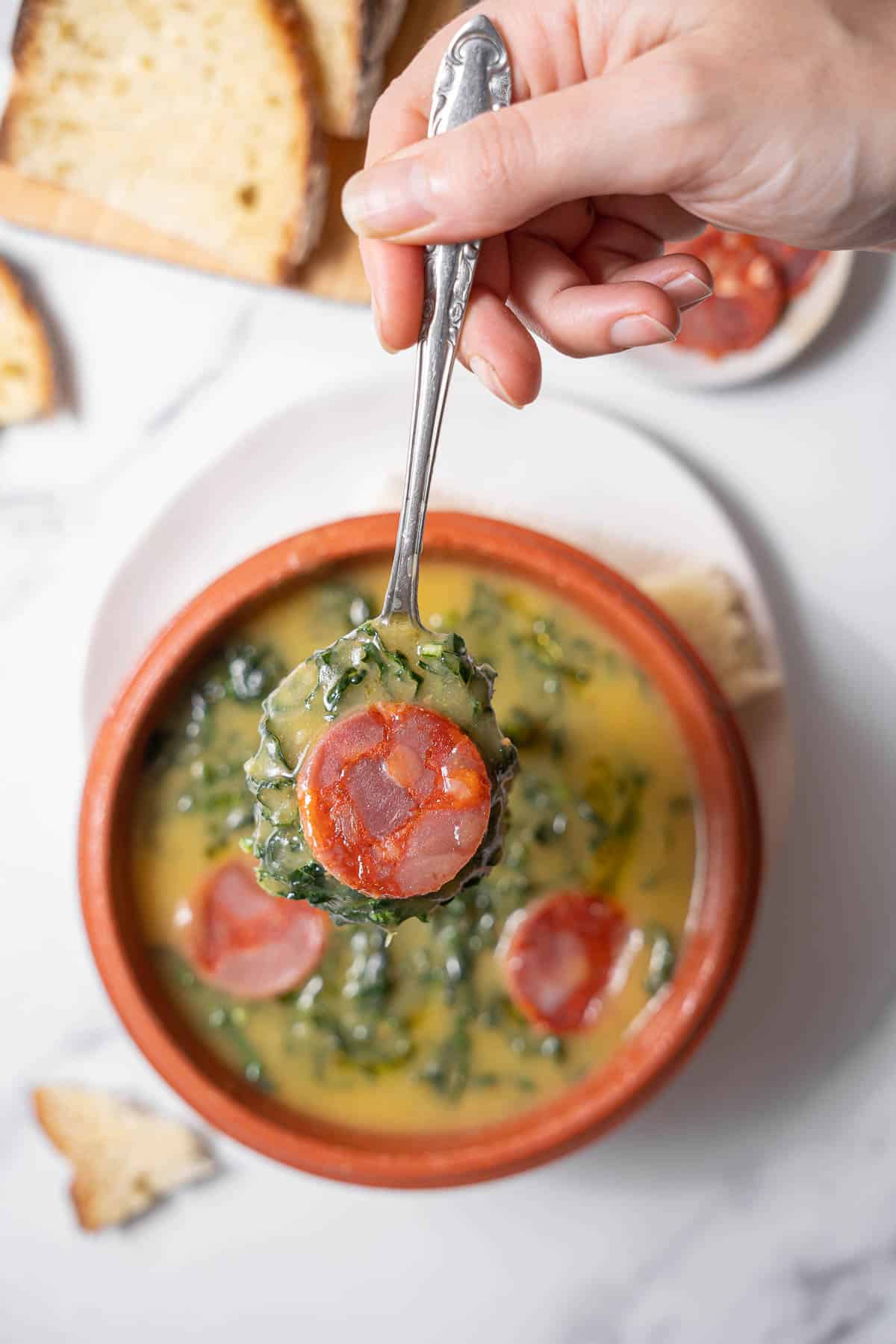 holding a spoonful of caldo verde.