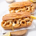 two fried calamari sandwiches on a board.