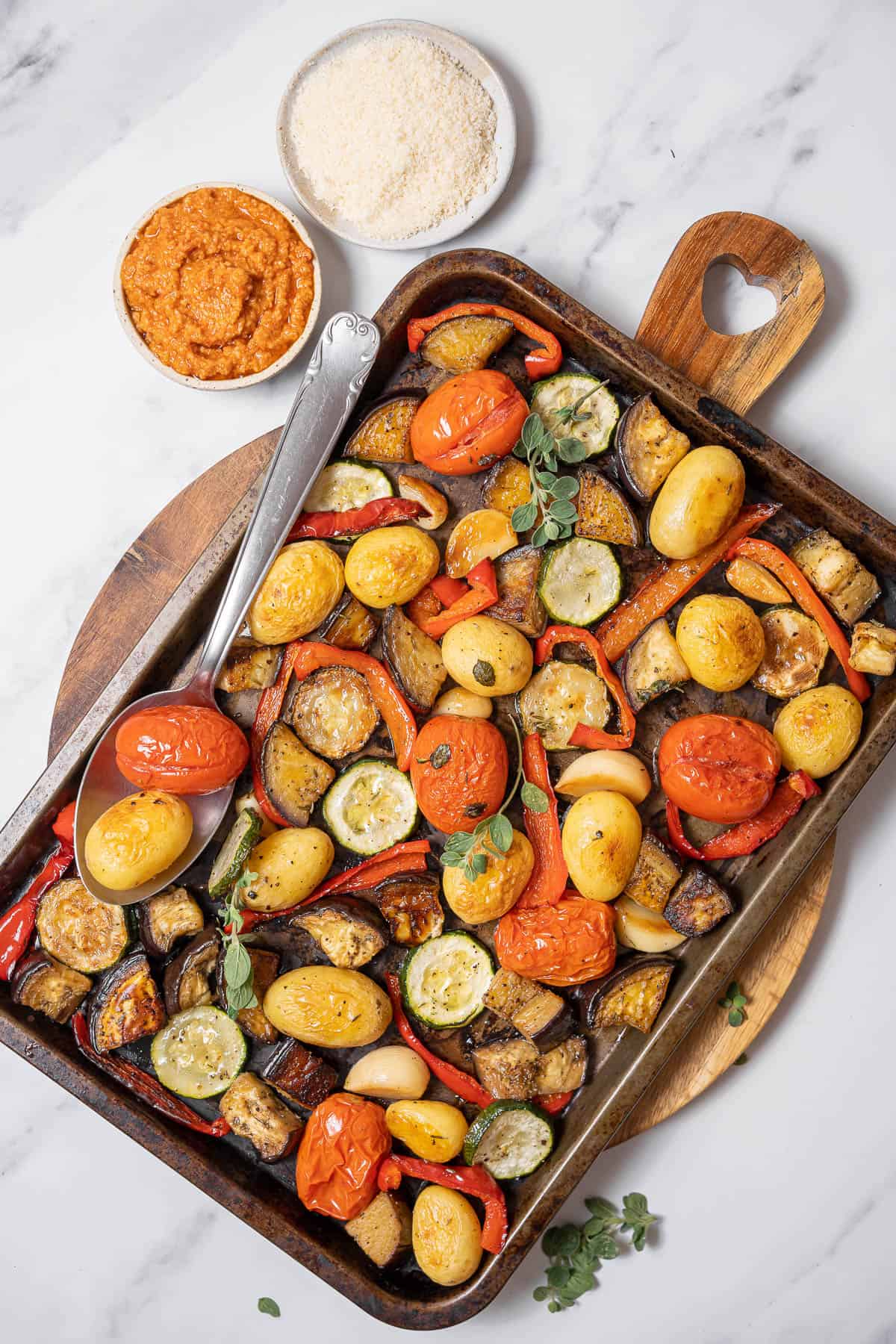 pan of roasted vegetables with cheese and dip.