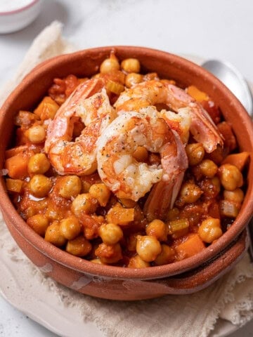 bowl of shrimp and chickpeas with a spoon.