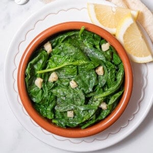 bowl of spinach with garlic and lemon.