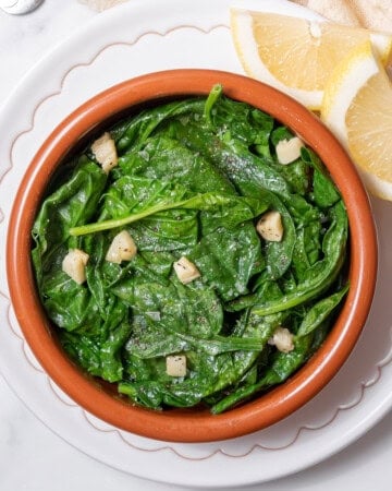 bowl of spinach with garlic and lemon.