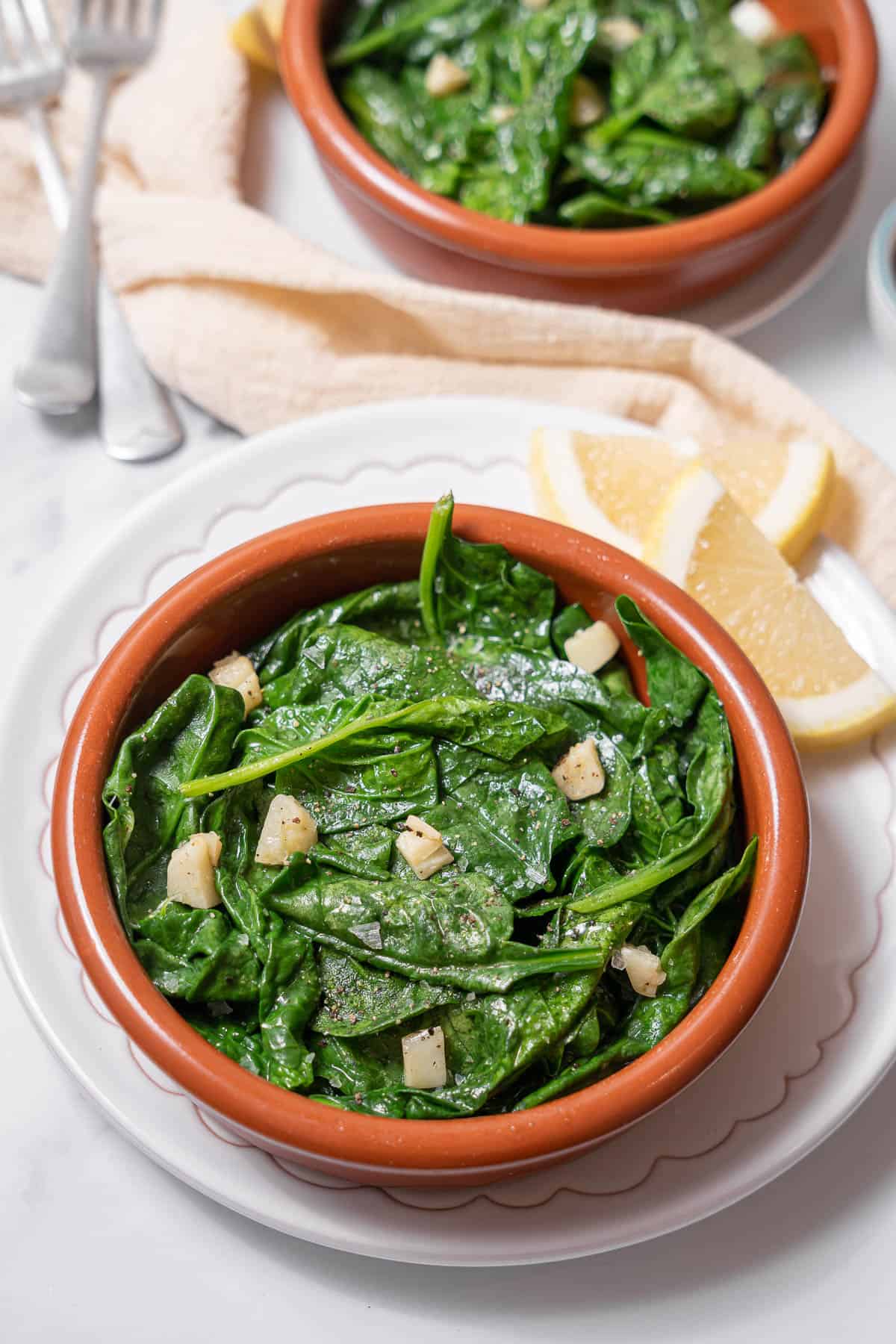 bowl of cooked spinach with lemon.