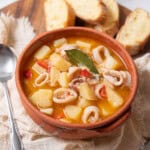 bowl of squid and potato stew with bread.