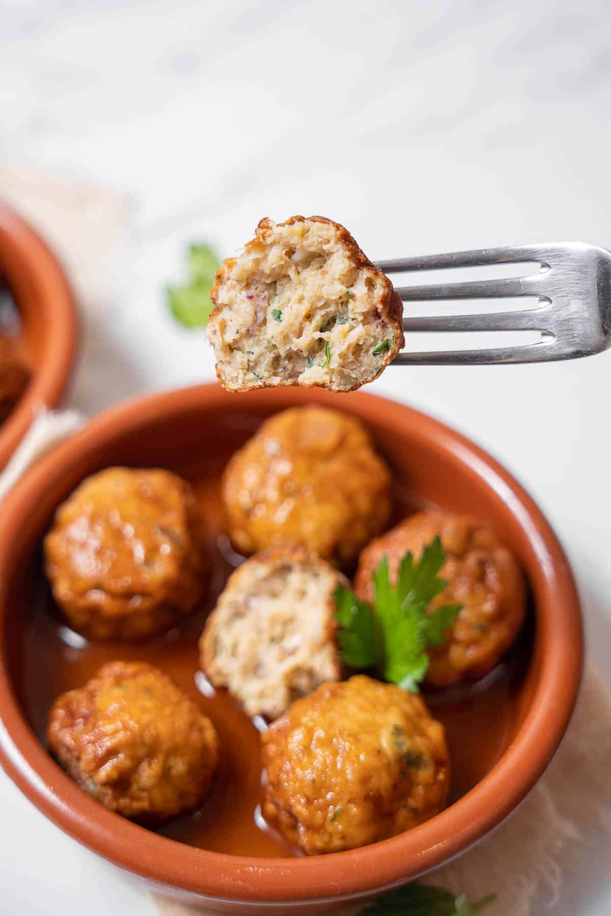 holding half of a cuttlefish meatball.