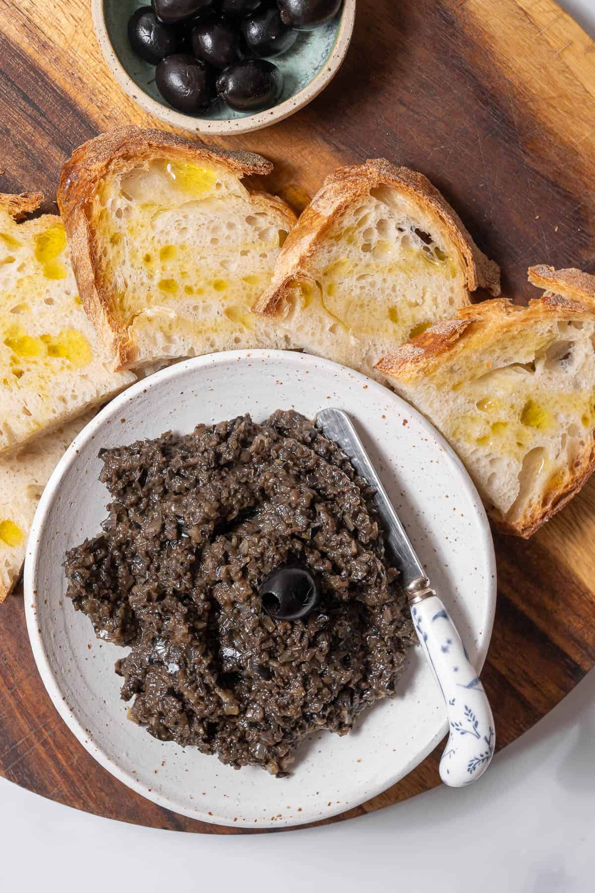 bowl of black olive tapenade with bread.