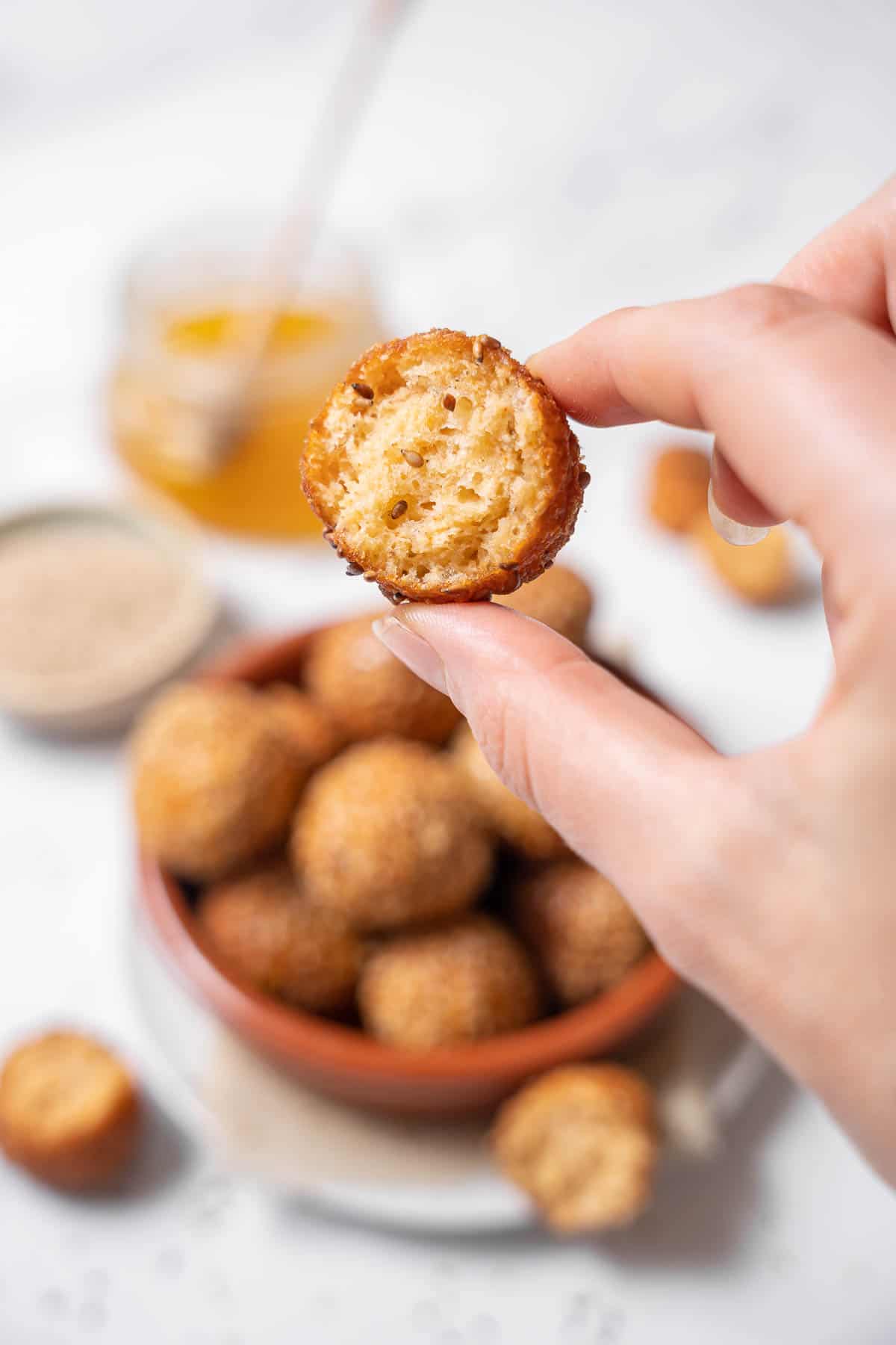 holding half of a cheese puff.