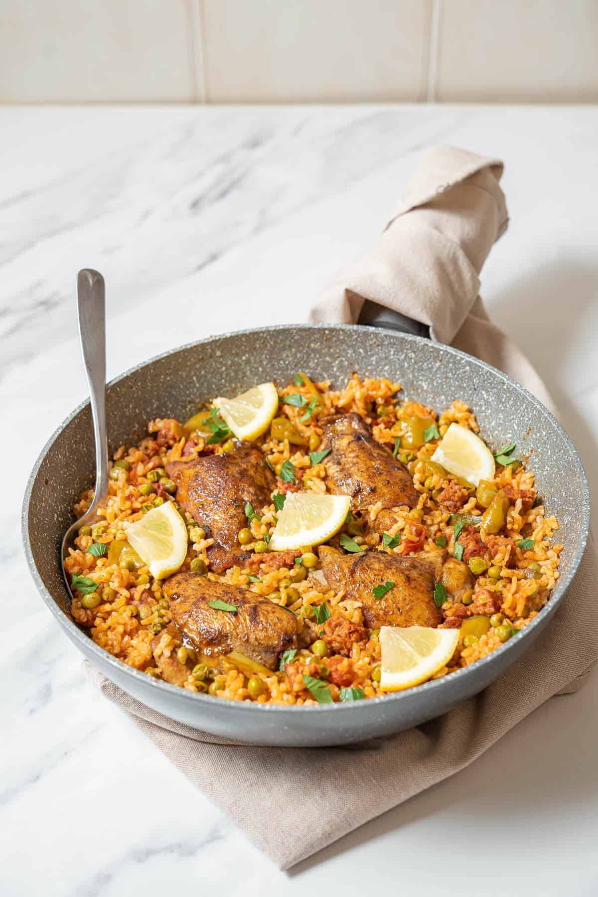 skillet of chicken and chorizo rice with a spoon.