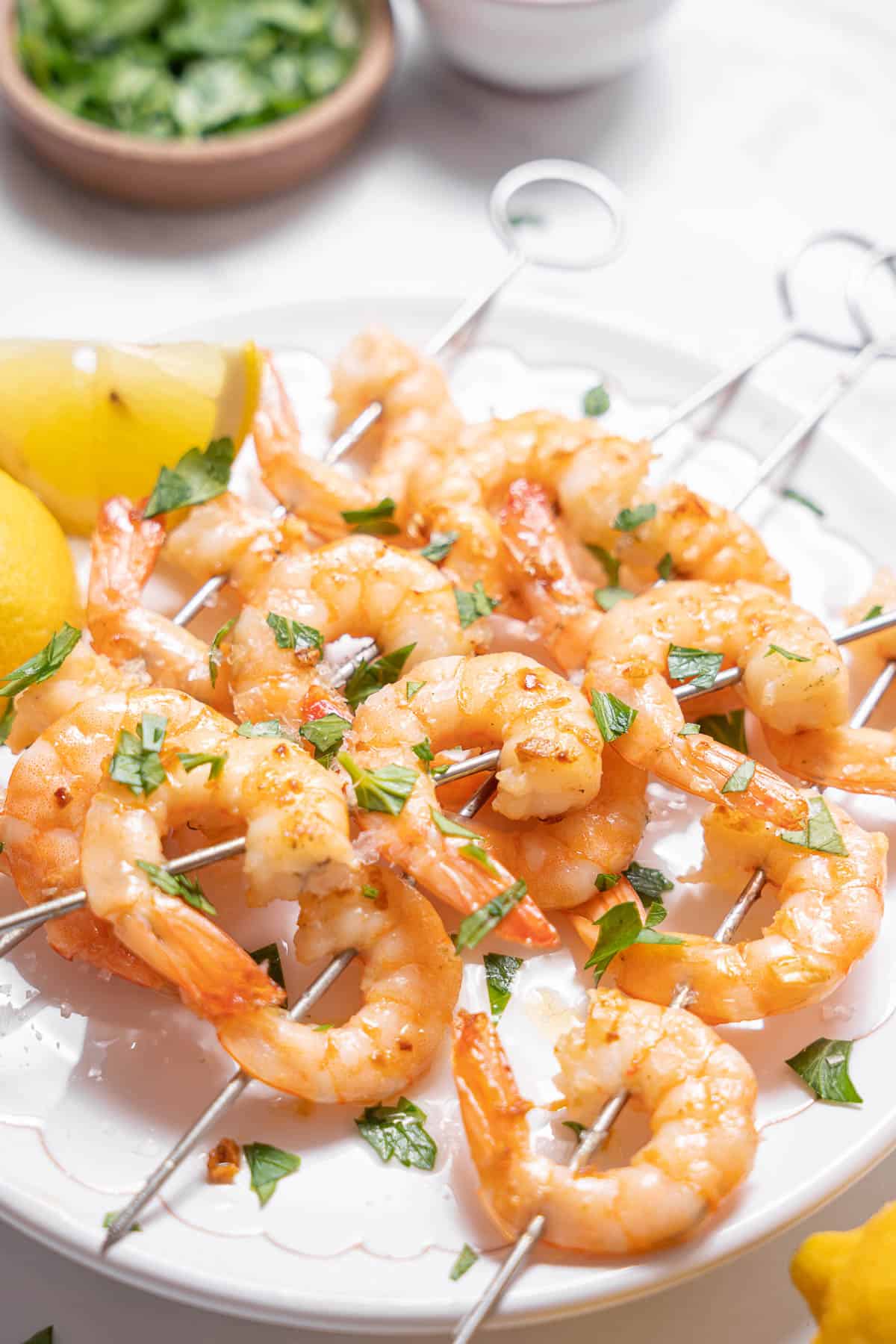 plate of gambas al ajillo with lemon wedges.