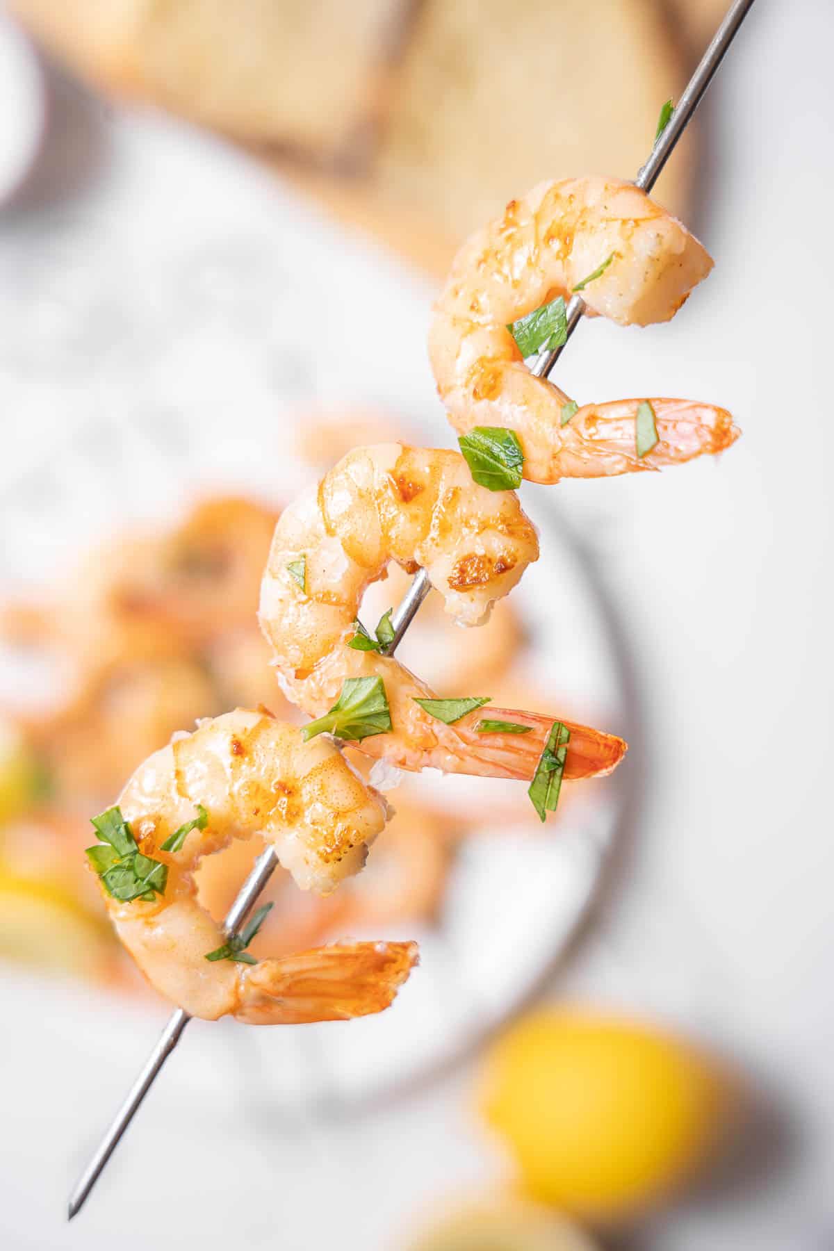 holding a gambas al ajillo skewer.