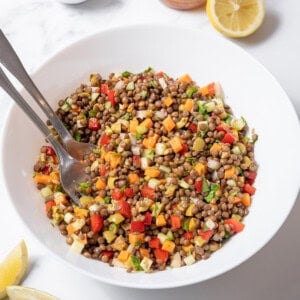 bowl of lentil salad with serving utensils.