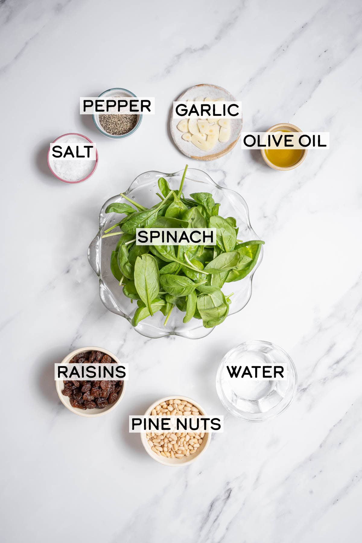 bowls of ingredients for spinach with pine nuts.