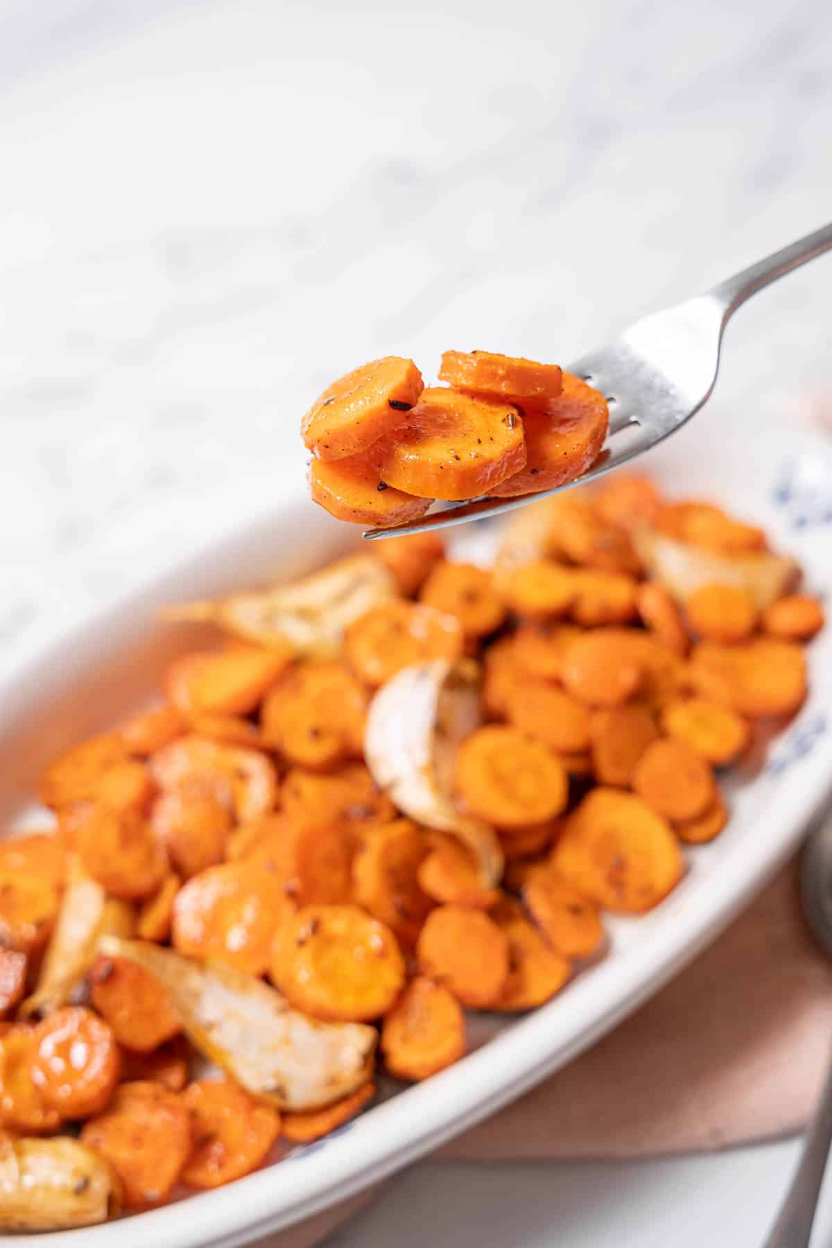 holding a forkful of Spanish roasted carrots.