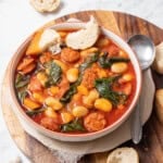 bowl of chorizo and white bean stew with bread.