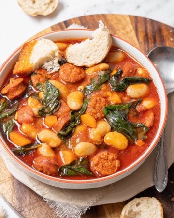 bowl of chorizo and white bean stew with bread.