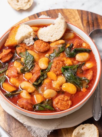 bowl of chorizo and white bean stew with bread.